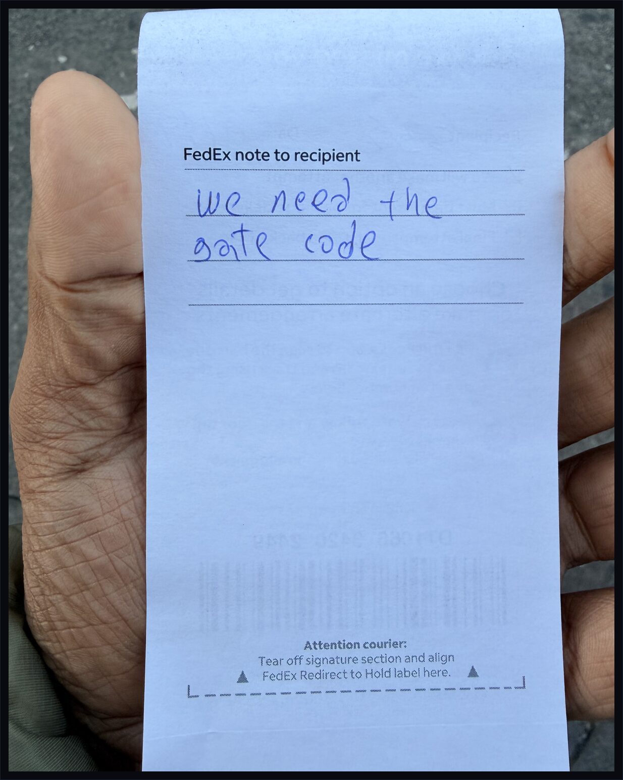 Back of the FedEx door tag with handwritten note: we need the gate code